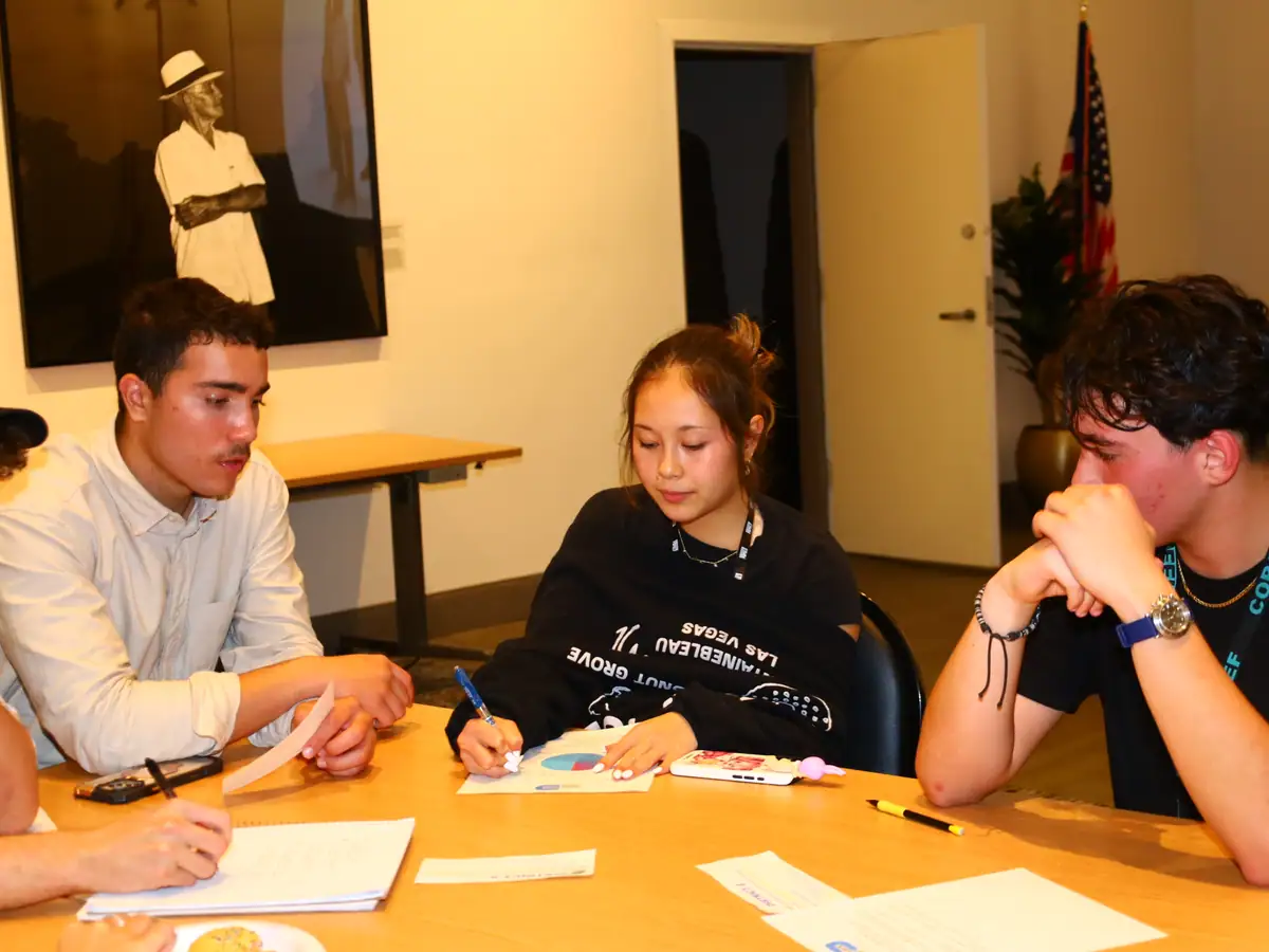 Fellows draft proposals across a library table.