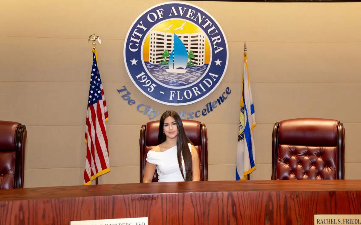 Seated at the commission dais of a participating municipality.