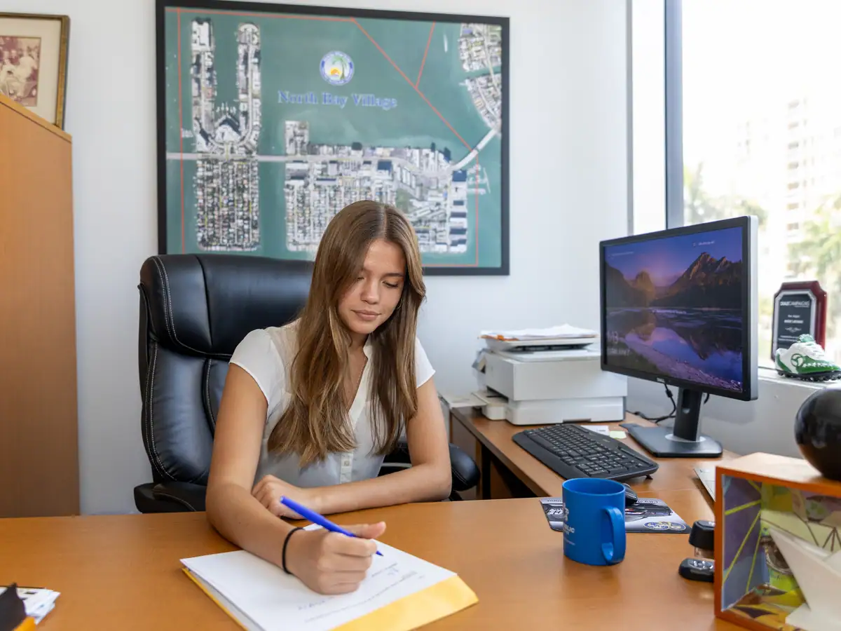 Working from a municipal office desk, city map on the wall.